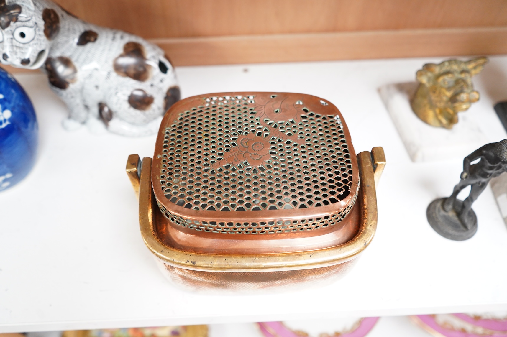 An 18th century Chinese engraved copper handwarmer with brass swing handle, 21cm wide